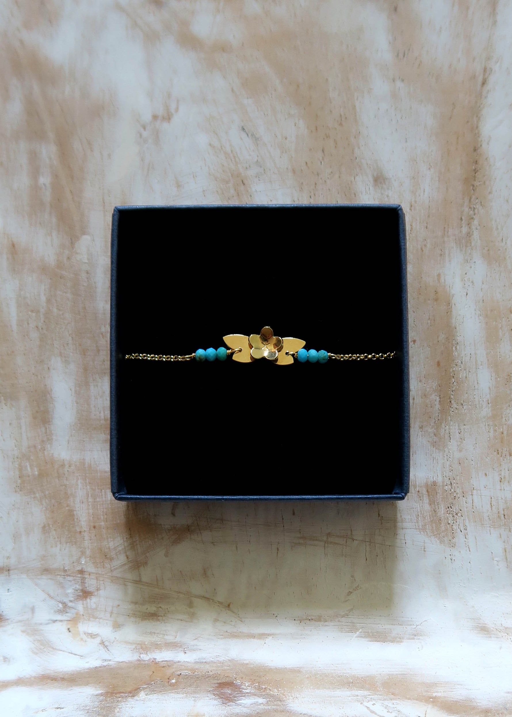 bracelet petite fleur dorée et perles en turquoise. Bijou fin et léger fabriqué en France