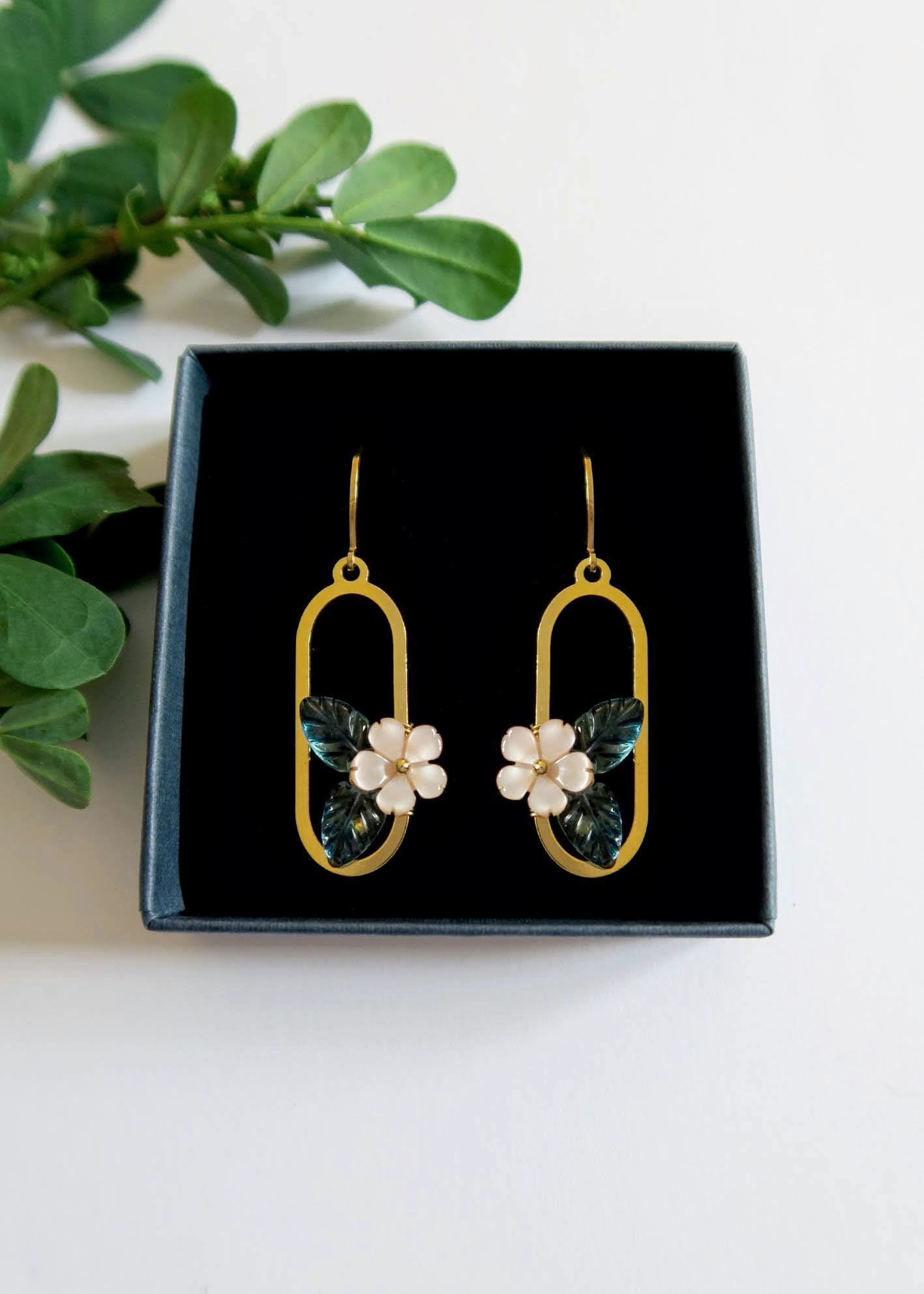 Paire de boucles d'oreilles dorée motif fleur en nacre et topaze bleu.
Bijoux fins et légers.