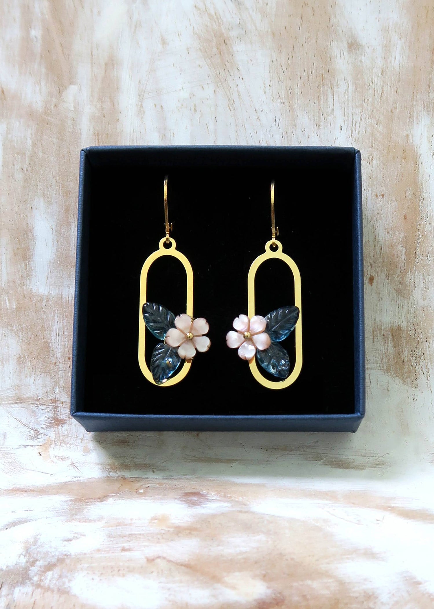 Boucles d'oreilles dorée motif fleur en nacre et topaze bleu.
Bijoux fins et légers.
