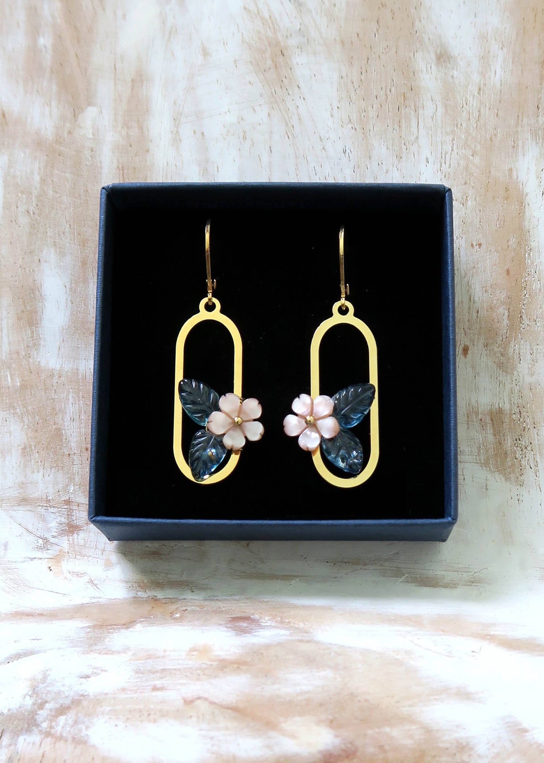 Boucles d'oreilles dorée motif fleur en nacre et topaze bleu.
Bijoux fins et légers.
