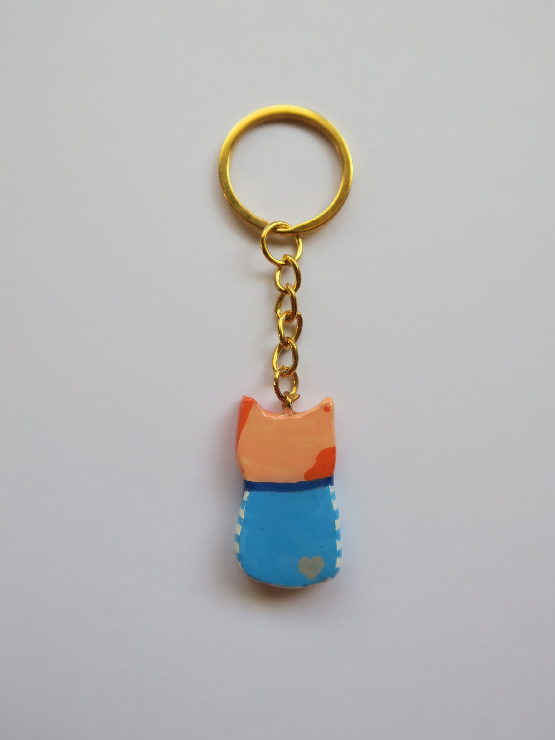Porte-clé Lucky Rolie Cat Émile — petit chat roux breton malicieux en marinière, modelé et peint à la main en argile, fini à la résine UV. Pièce unique fait main en Bretagne.