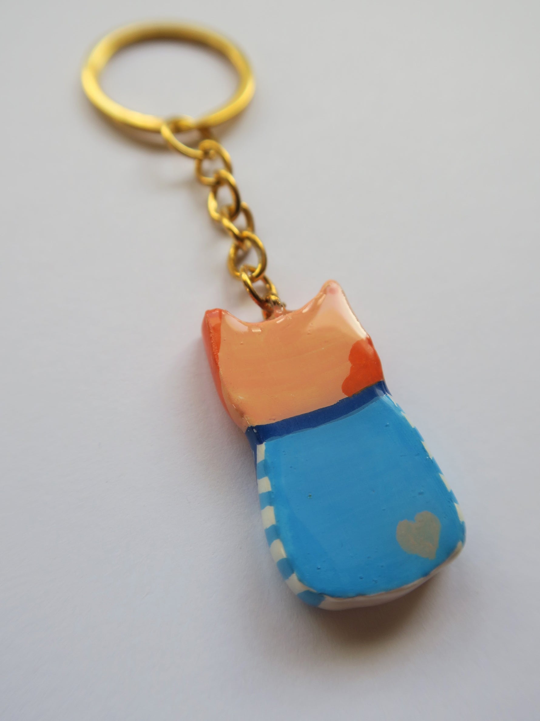 Porte-clé Lucky Rolie Cat Émile — petit chat roux breton malicieux en marinière, modelé et peint à la main en argile, fini à la résine UV. Pièce unique fait main en Bretagne.