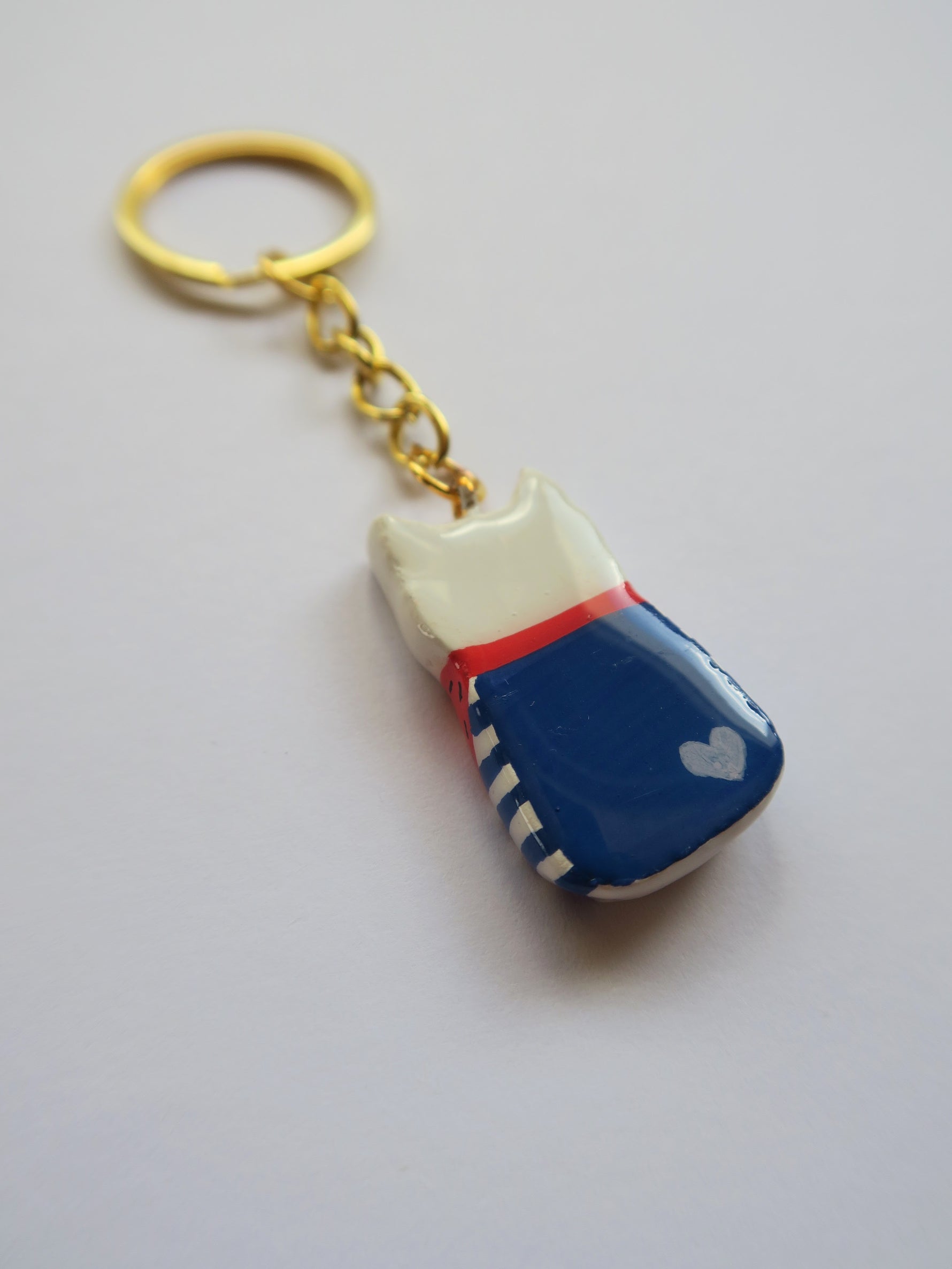 Porte-clé Lucky Rolie Cat Gwendal — petit chat tricolore breton en marinière bleu marine, modelé et peint à la main en argile, fini à la résine UV. Avec un petit coeur au recto
