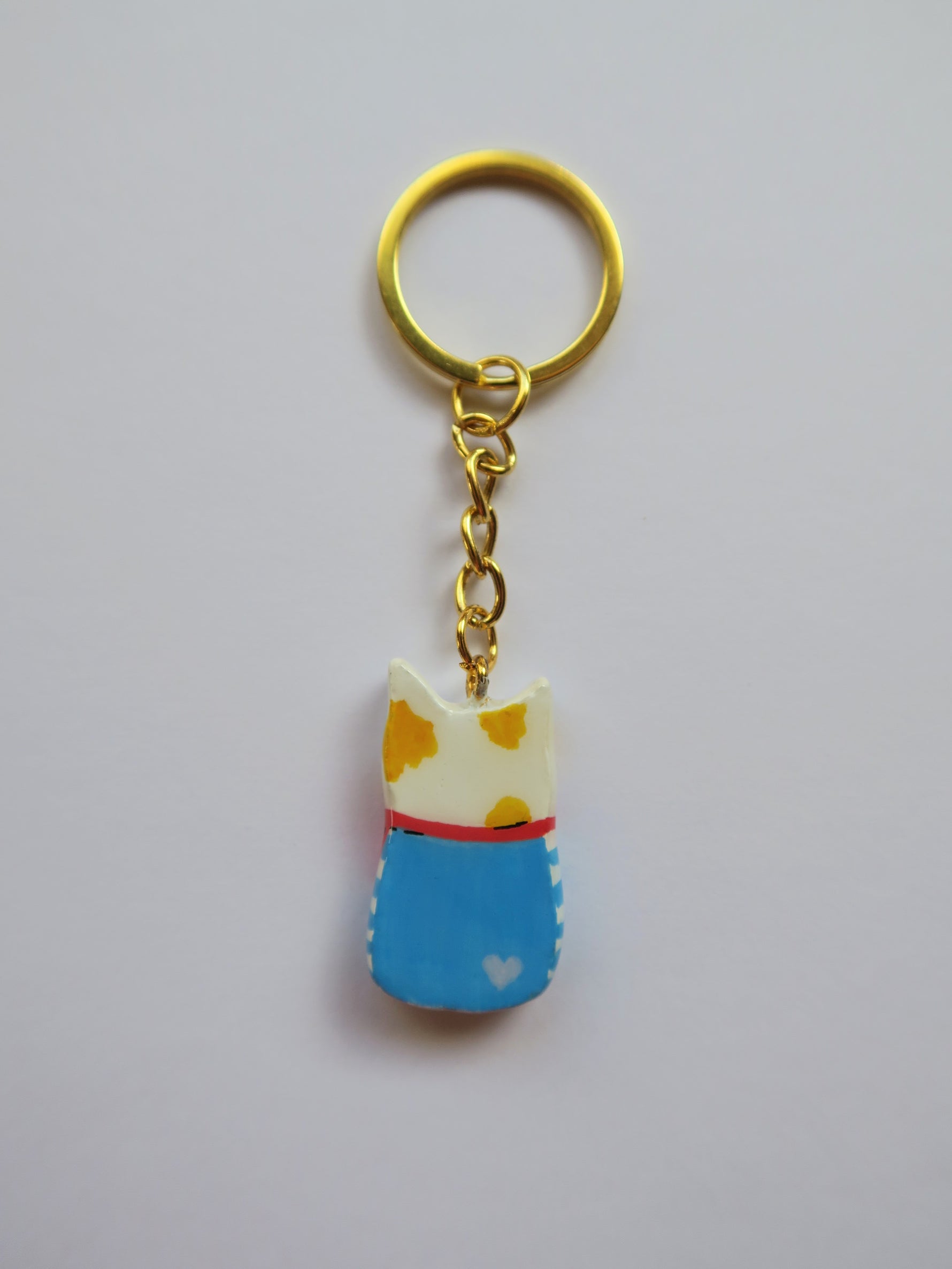 Porte-clé Lucky Rolie Cat Loïc — petit chat blanc breton joyeux en marinière, modelé et peint à la main en argile, fini à la résine UV. Pièce unique fait main en Bretagne.