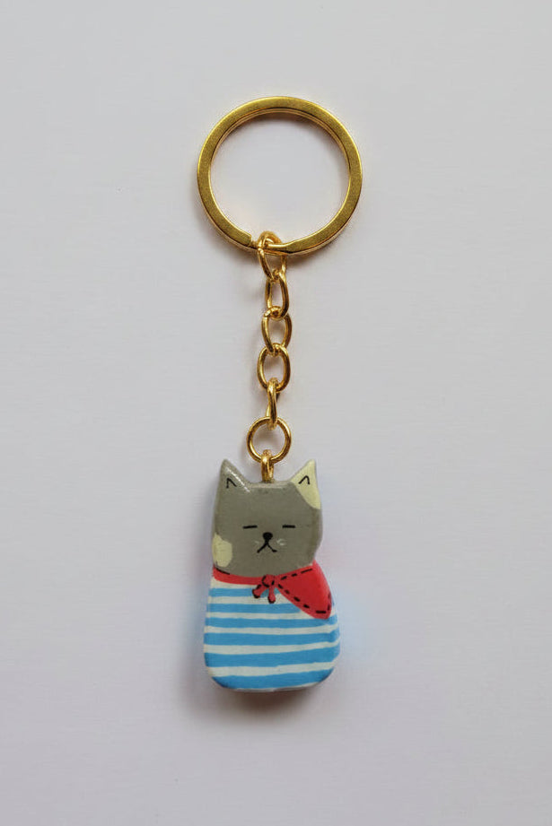 Porte-clé Lucky Rolie Cat Paul — petit chat gris breton en marinière, modelé et peint à la main en argile, fini à la résine UV. Pièce unique fait main en Bretagne.
