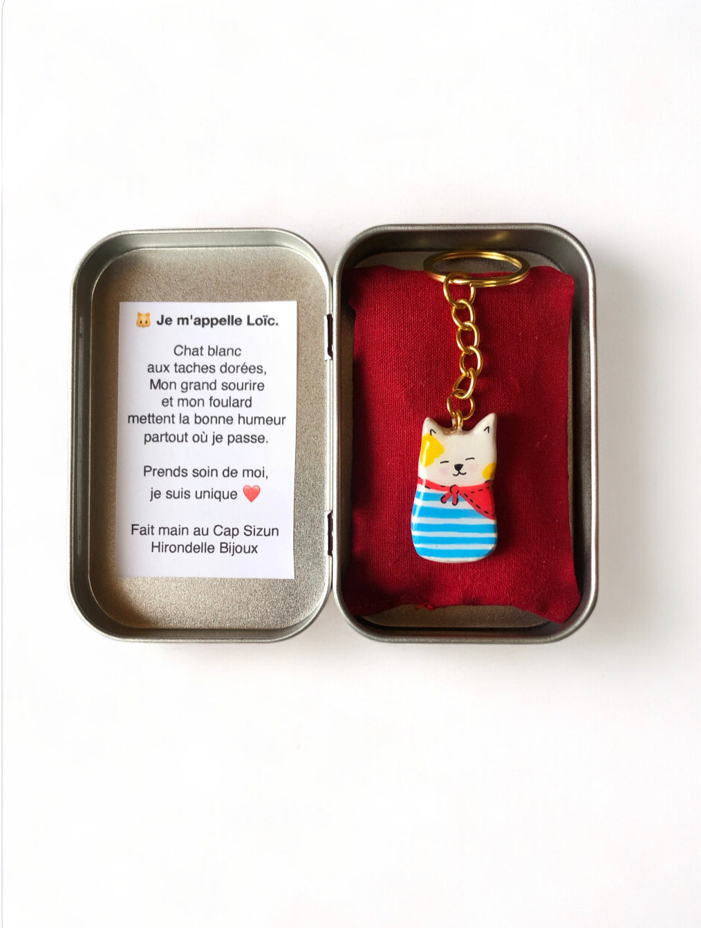 Porte-clé Lucky Rolie Cat Loïc — petit chat blanc breton joyeux en marinière, modelé et peint à la main en argile, fini à la résine UV. Pièce unique fait main en Bretagne.