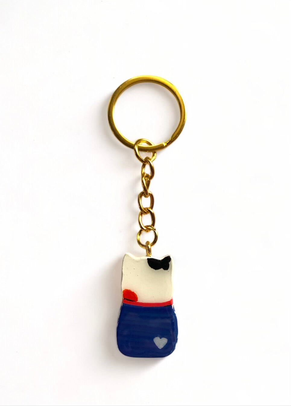 Porte-clé Lucky Rolie Cat Gwendal — petit chat tricolore breton en marinière bleu marine, modelé et peint à la main en argile, fini à la résine UV. Pièce unique fait main en Bretagne.