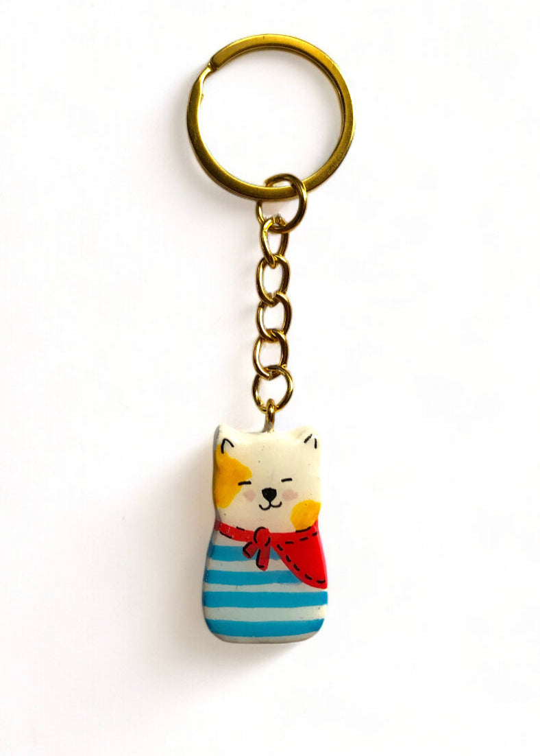 Porte-clé Lucky Rolie Cat Loïc — petit chat blanc breton joyeux en marinière, modelé et peint à la main en argile, fini à la résine UV. Pièce unique fait main en Bretagne.