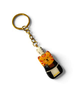 Porte-clé Lucky Rolie Cat Soizic — chatte bigoudène rousse en costume traditionnel, modelée et peinte à la main en argile, finie à la résine UV. Fait main au Cap Sizun.