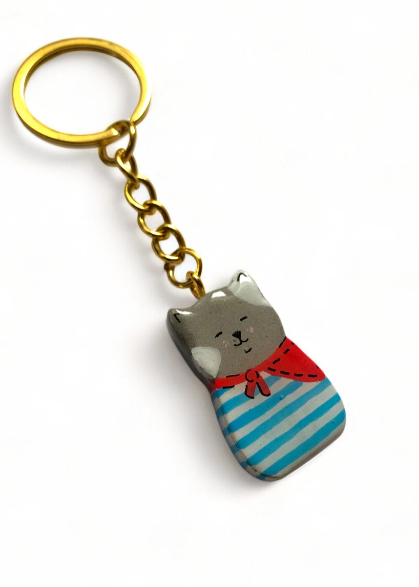 Porte-clé Lucky Rolie Cat Paul — petit chat gris breton en marinière, modelé et peint à la main en argile, fini à la résine UV. Pièce unique fait main en Bretagne.