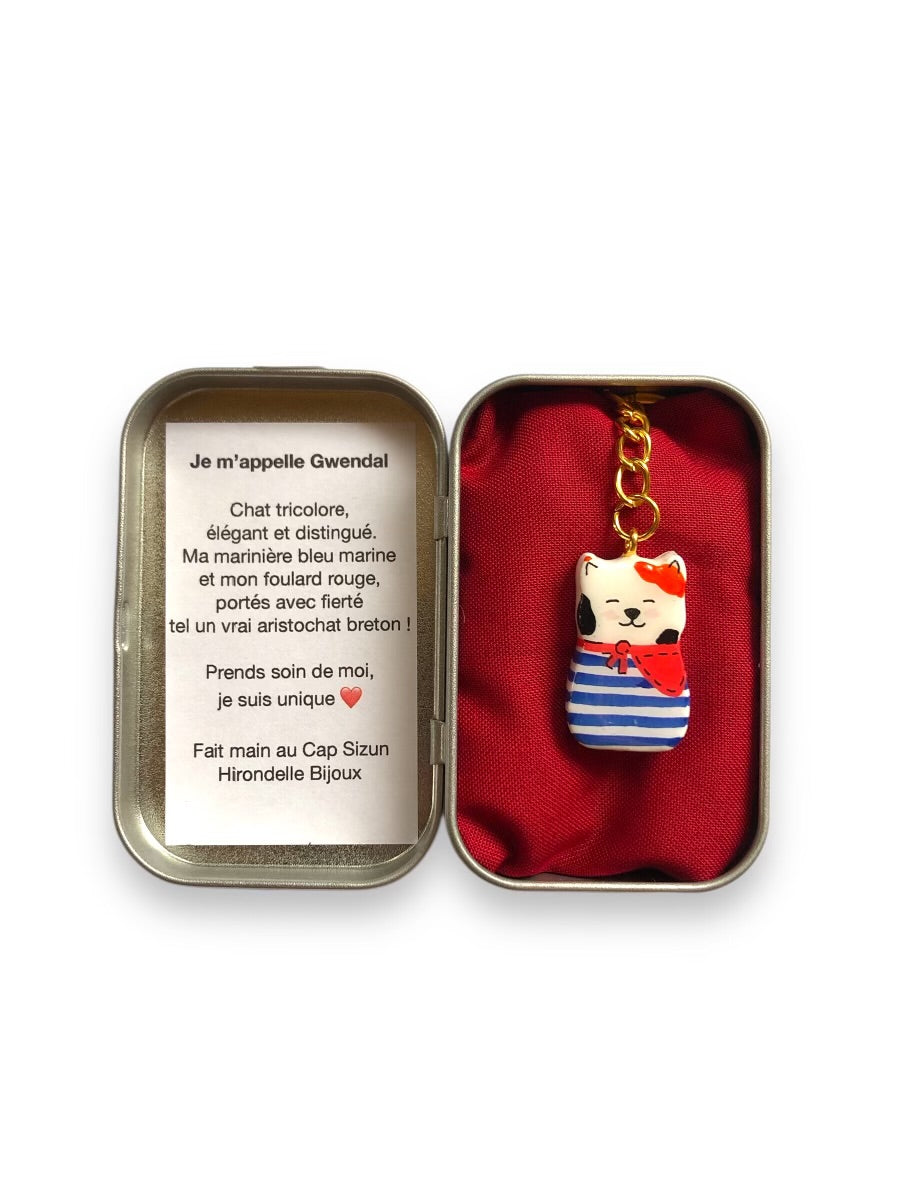 Porte-clé Lucky Rolie Cat Gwendal — petit chat tricolore breton en marinière bleu marine, modelé et peint à la main en argile, fini à la résine UV. Pièce unique fait main en Bretagne.