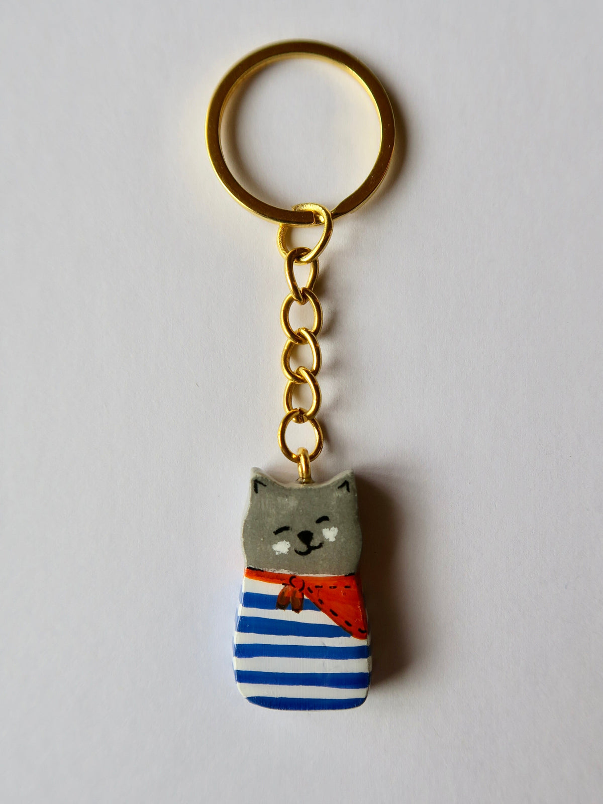 Porte-clé Lucky Rolie Cat Martin — petit chat gris breton en marinière, modelé et peint à la main en argile, fini à la résine UV. Pièce unique fait main en Bretagne.