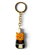 Porte-clé Lucky Rolie Cat Soizic — chatte bigoudène rousse en costume traditionnel, modelée et peinte à la main en argile, finie à la résine UV. Fait main au Cap Sizun.