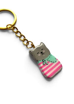 Porte-clé Lucky Rolie Cat Malo — petit chat gris breton en marinière rose et foulard turquoise, modelé et peint à la main en argile, fini à la résine UV. Fait main au Cap Sizun.