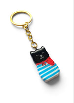 Porte-clé Lucky Rolie Cat Gabin — petit chat noir breton en marinière bleue et foulard rouge, modelé et peint à la main en argile, fini à la résine UV. Fait main au Cap Sizun.