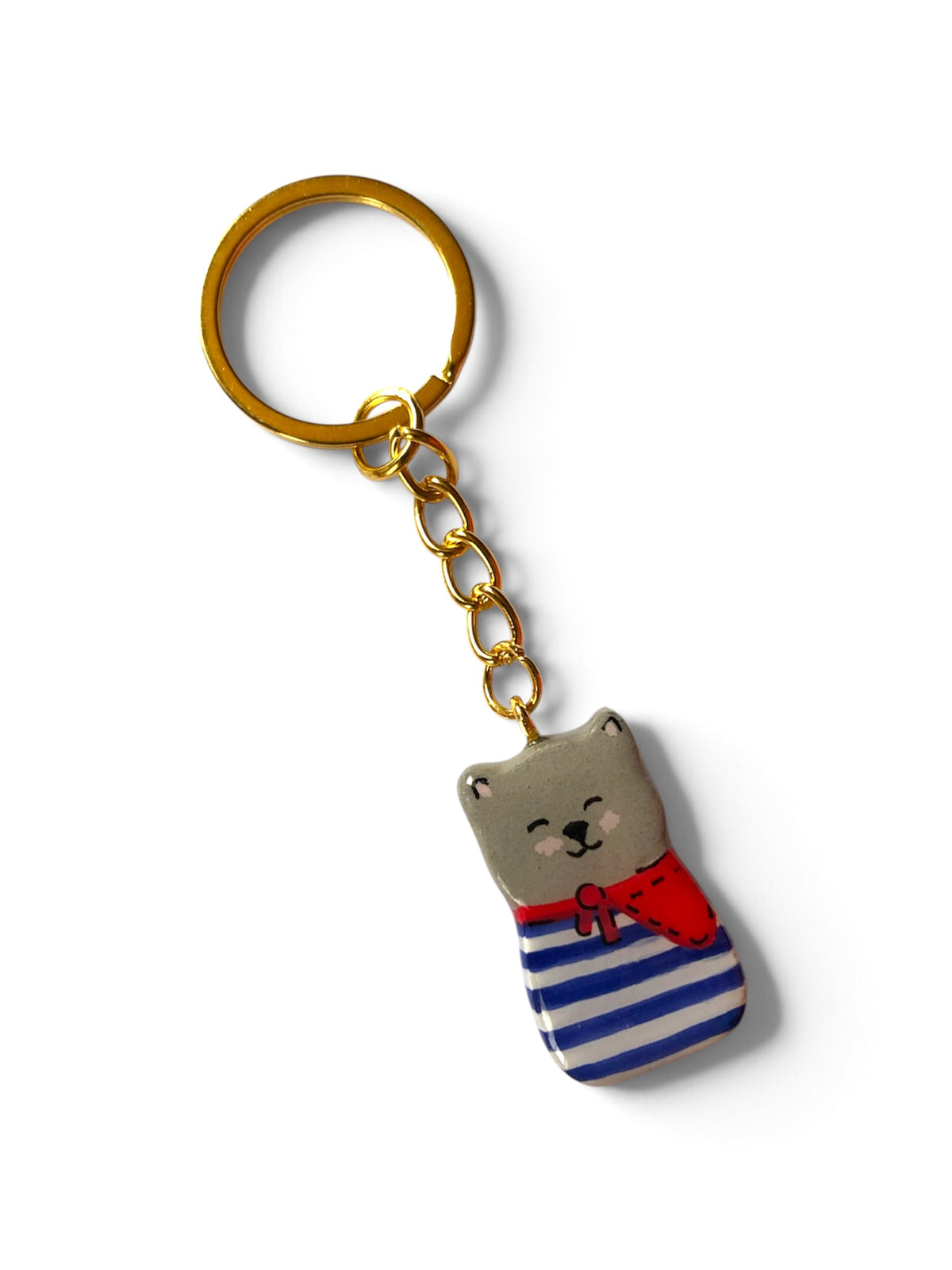 Porte-clé Lucky Rolie Cat martin — petit chat gris breton en marinière rose pastel et foulard bleu, modelé et peint à la main en argile, fini à la résine UV. Fait main au Cap Sizun.