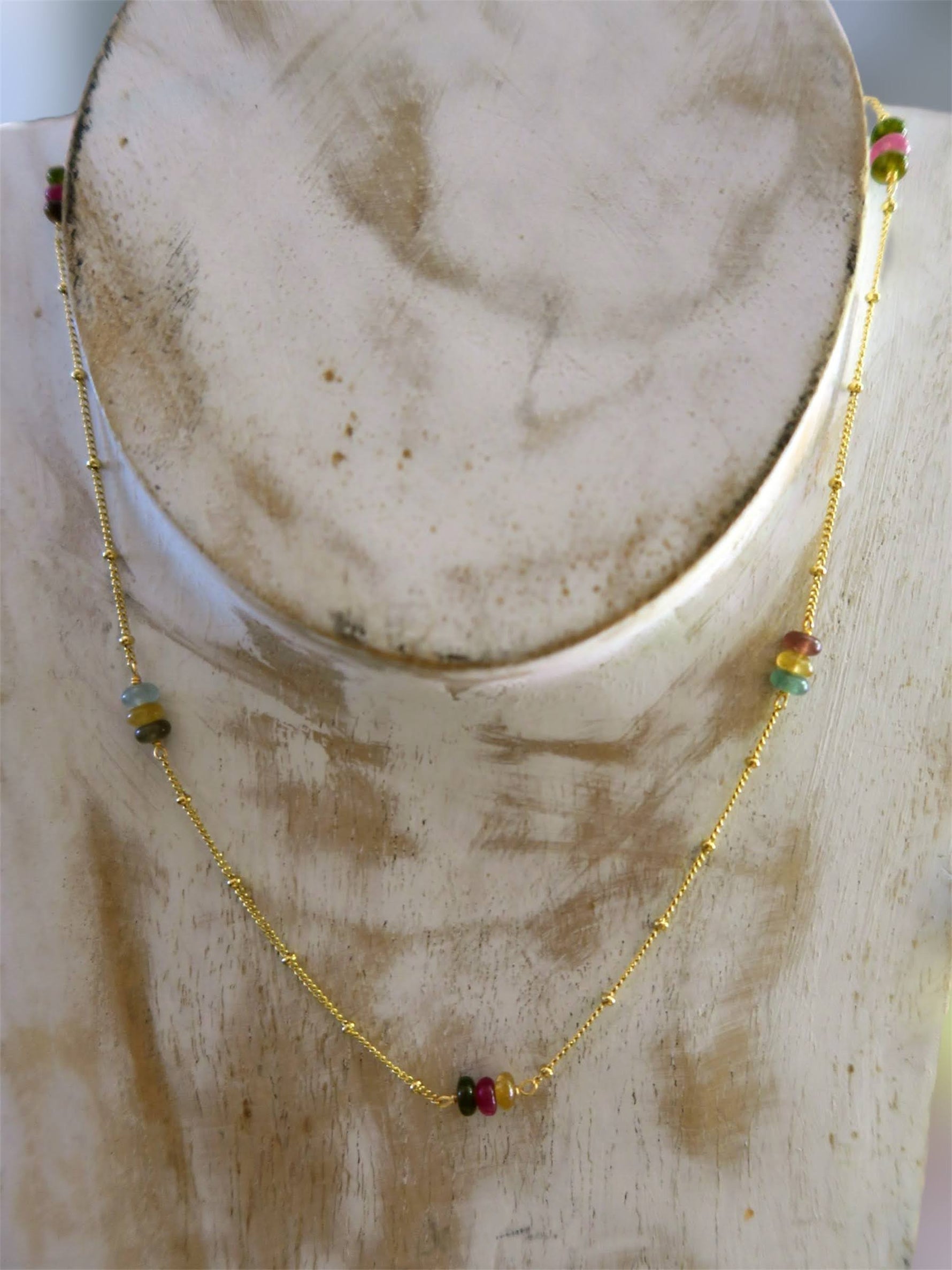collier coloré fin et leger sur buste en bois