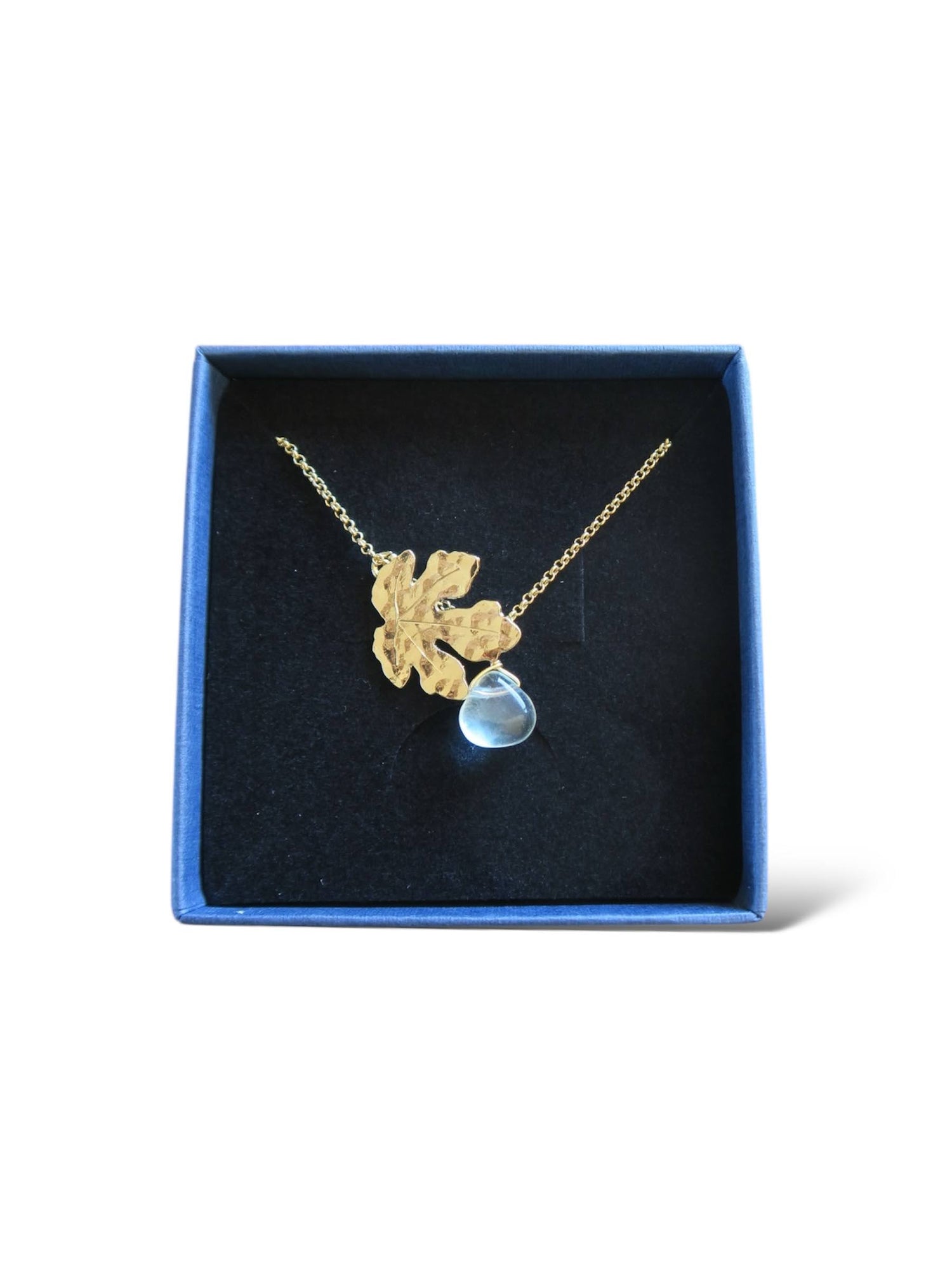 collier féminin célébrant la nature en représentant une feuille de figuier doré dans un écrin