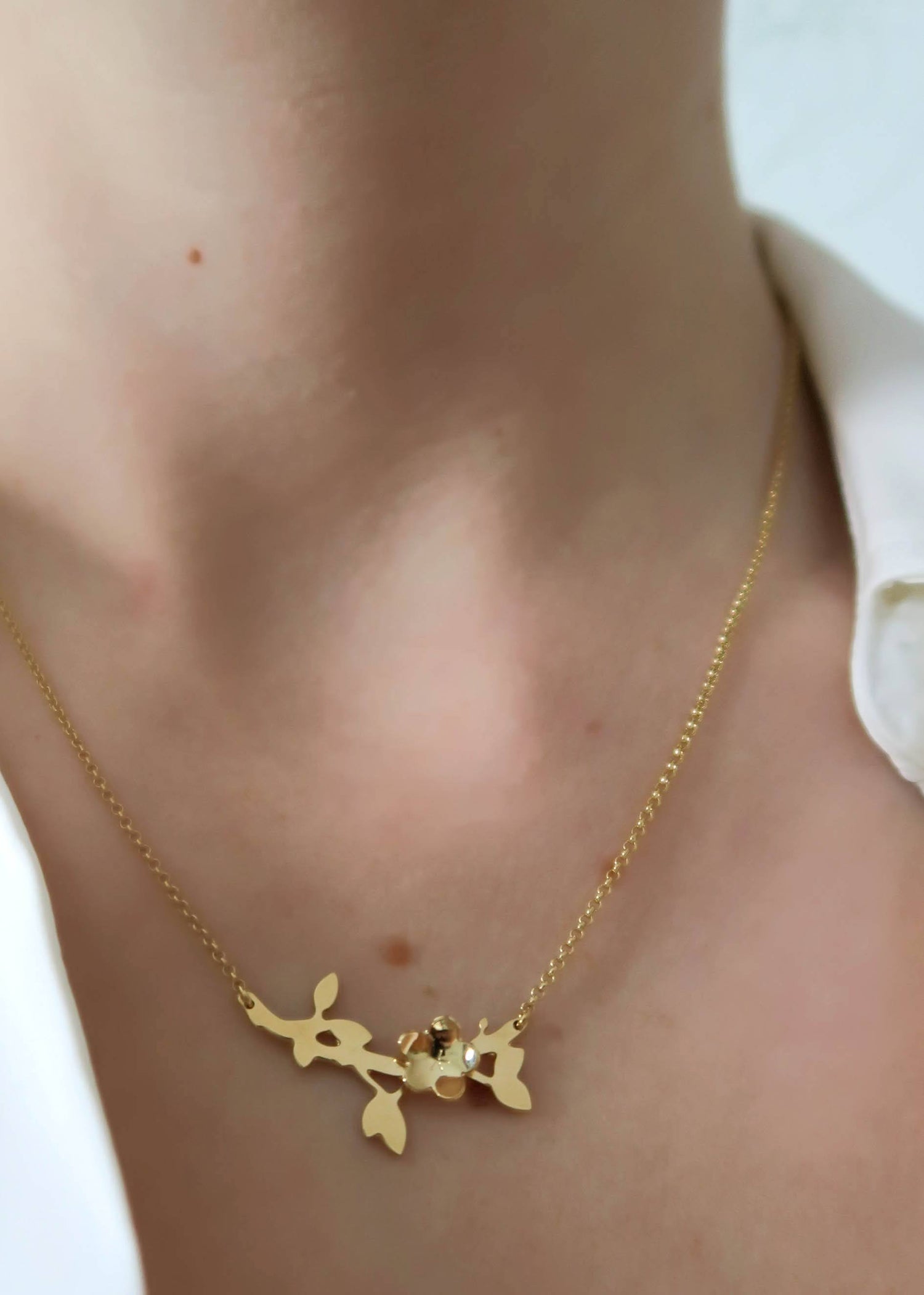 collier laiton doré motif fleur sur buste