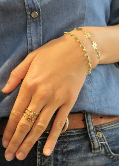 Mise en situation de la bague sesame en tourmalines et du bracelet bouquet doré à l’or fin, créés par la marque artisanale Hirondelle Bijoux