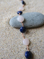 gros plan pierres de lapis lazuli et quartz rose sur cordon 