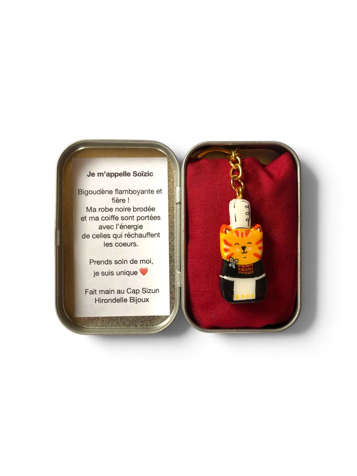 Porte-clé ou bijou des sac Lucky Rolie Cat Soizic — chatte bigoudène rousse en costume traditionnel, modelée et peinte à la main en argile, finie à la résine UV. Fait main au Cap Sizun.