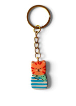 Porte-clé Lucky Rolie Cat Yannick — chat roux breton en marinière, modelé et peint à la main en argile, finie à la résine UV. Fait main au Cap Sizun.