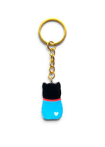 Porte-clé Lucky Rolie Cat Gabin — petit chat noir porte bonheur en marinière bleue et foulard rouge, modelé et peint à la main en argile, fini à la résine UV. Fait main au Cap Sizun.